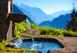 Water,Spring,On,Alps,Mountains,Background.